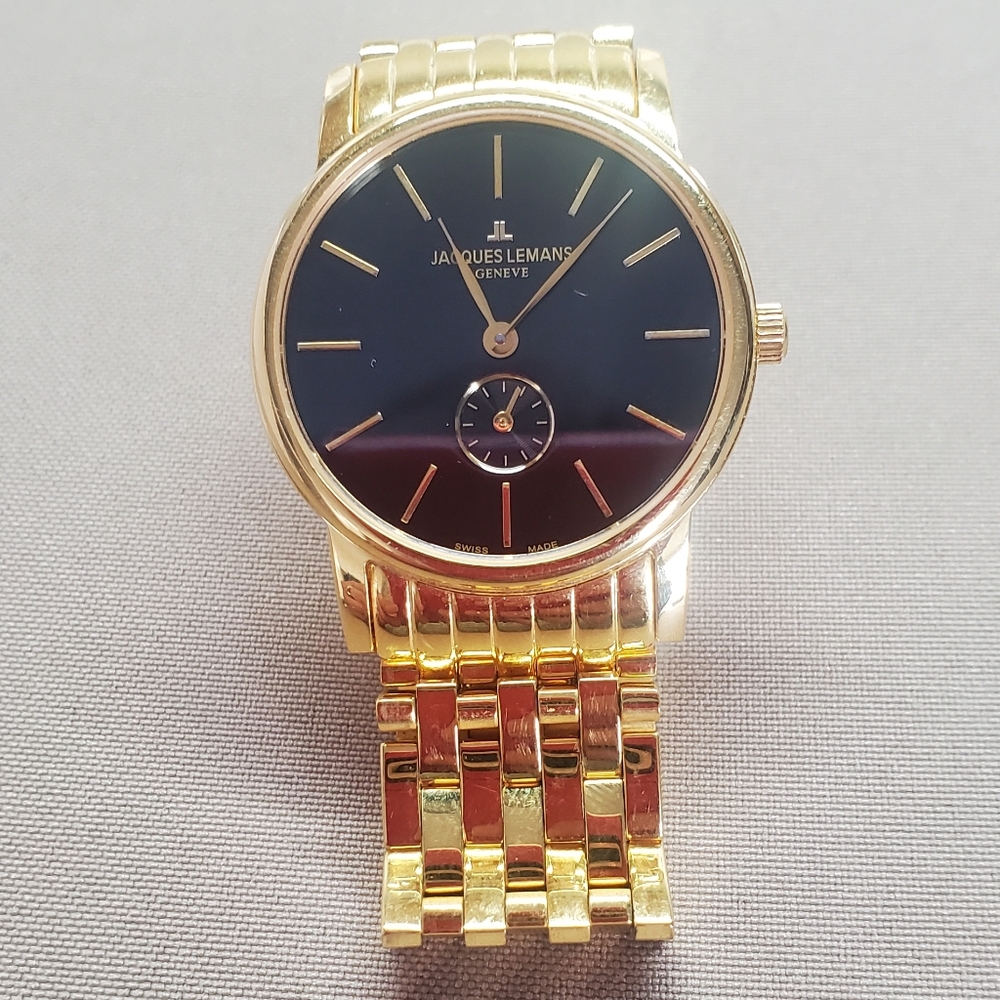 Jacque Lemans wrist watch. Gold band with black face